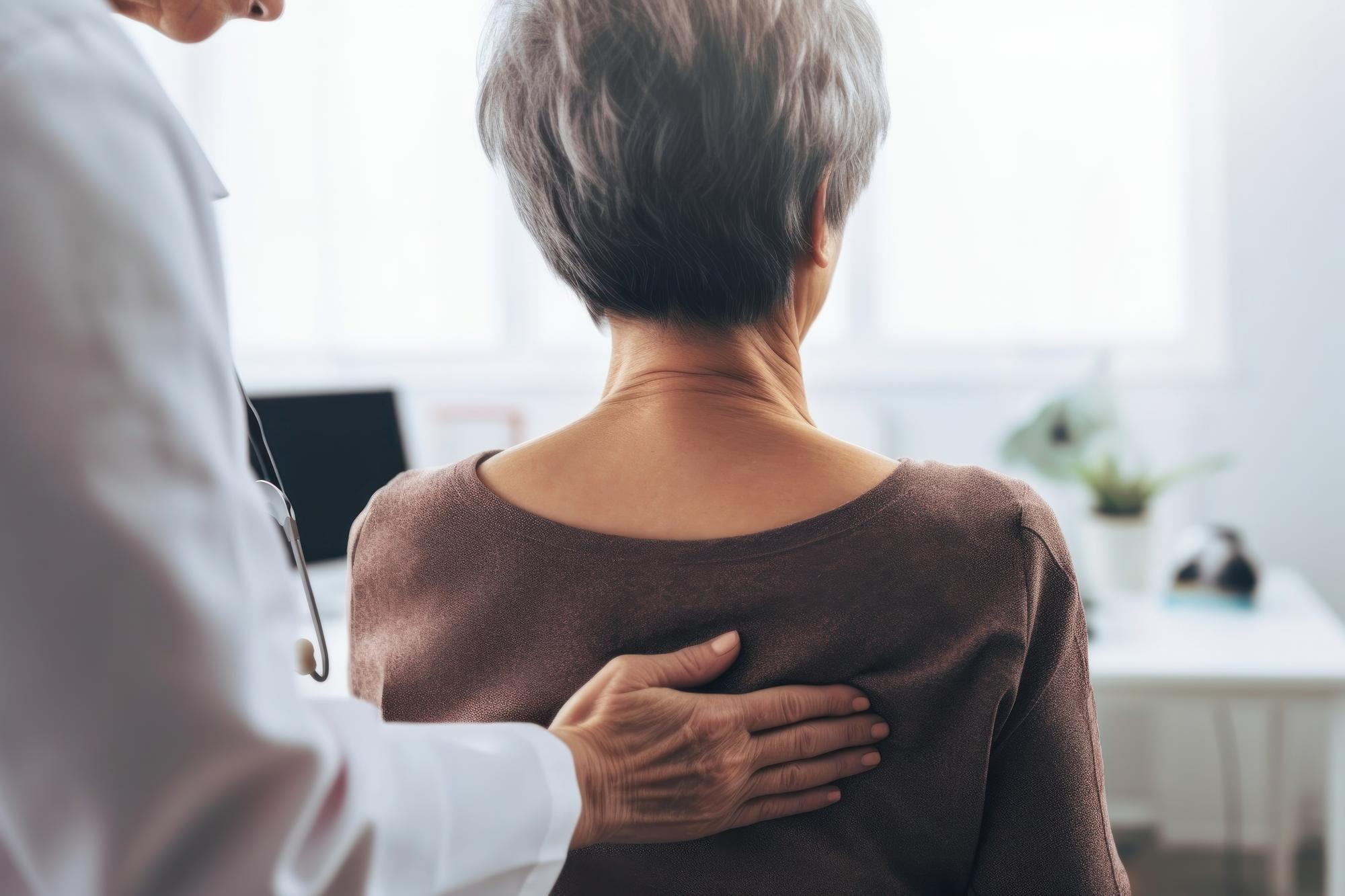 Ärztin hält Hand auf Rücken einer Patientin